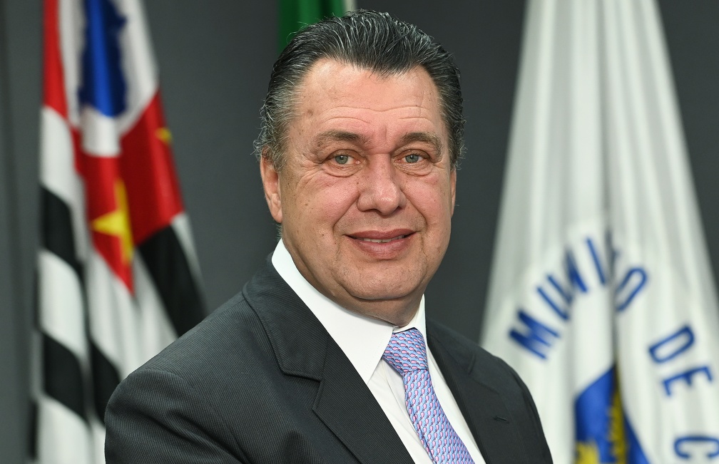 Fotografia do secretário Luiz Henrique Cirilo com bandeiras ao fundo