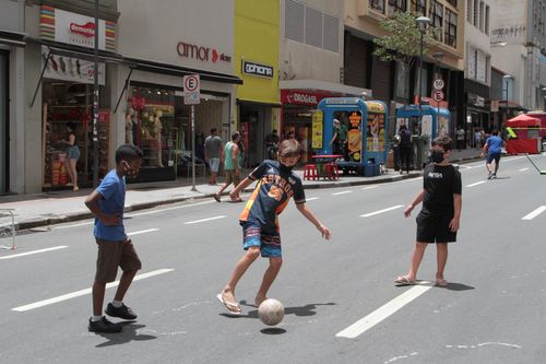 Crianças jogam bola na Avenida