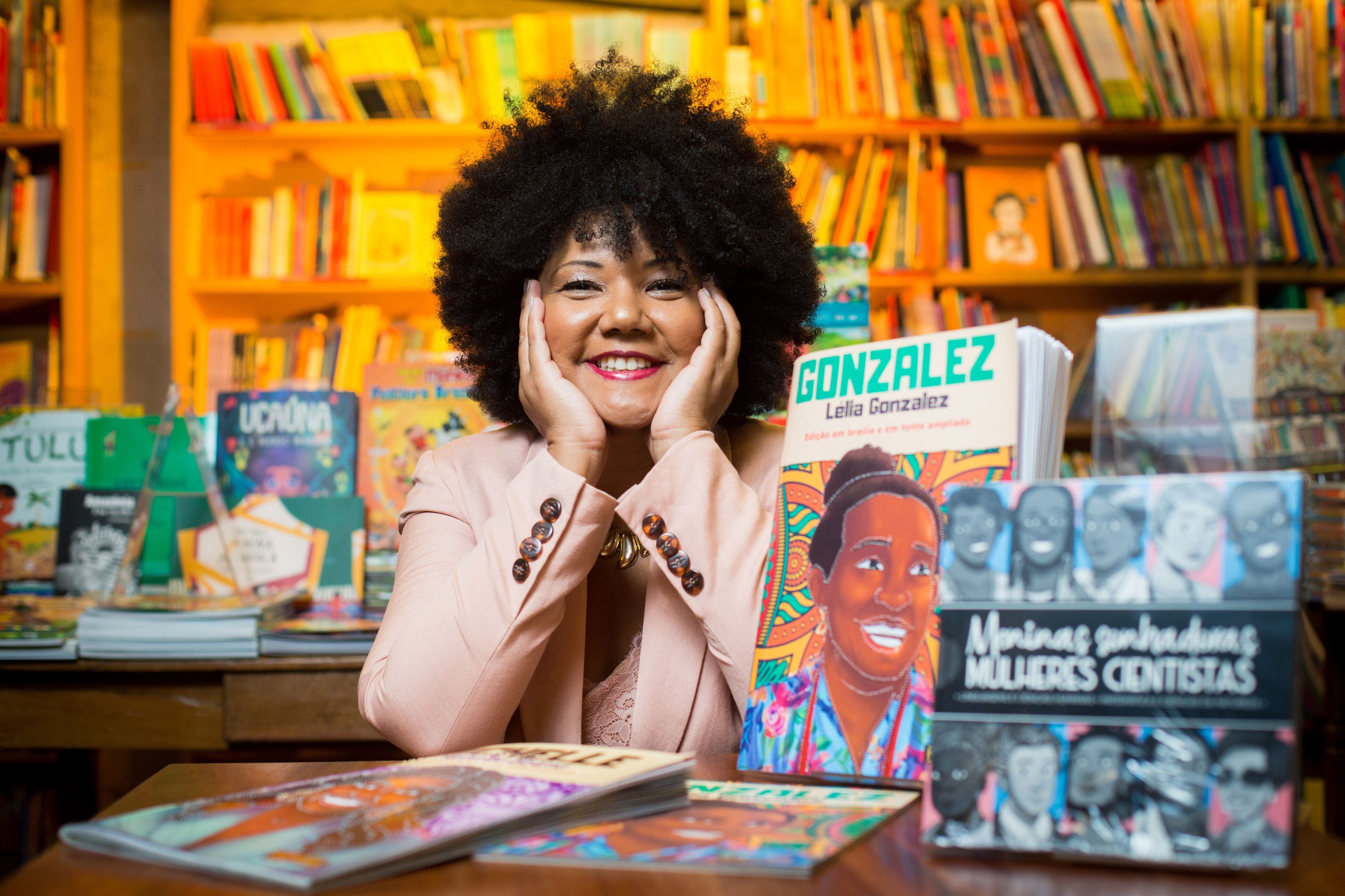Divulgação Flávia entre seus livros publicados: “Meninas Sonhadoras Mulheres Cientistas”, “Diário de uma ausência: Fragmentos de memória” e “Gonzalez - Lélia Gonzalez”