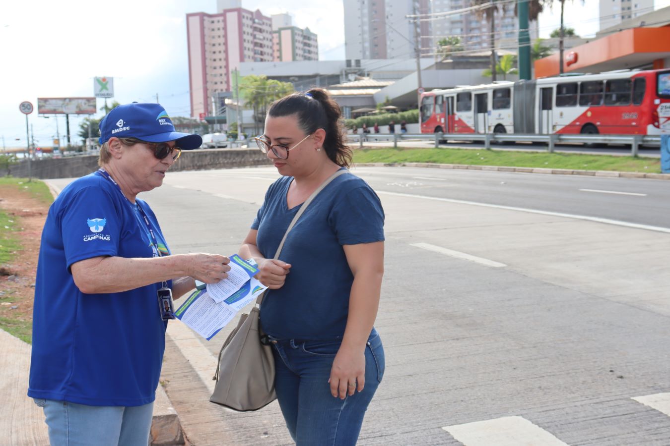 Funcionária da Emdec orienta passageira e entrega material informativo