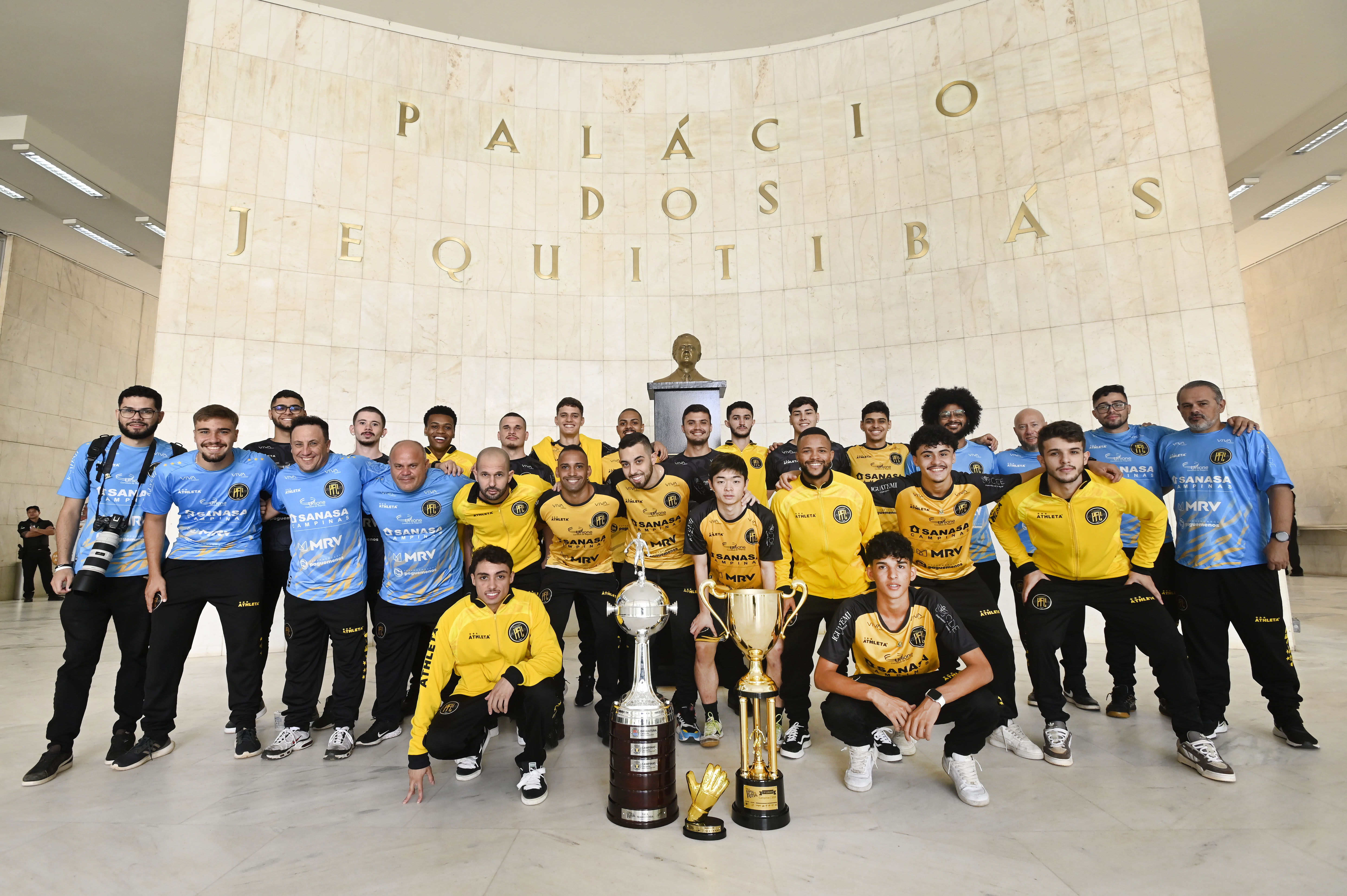 Equipe posa com os troféus no saguão do Paço Municipal