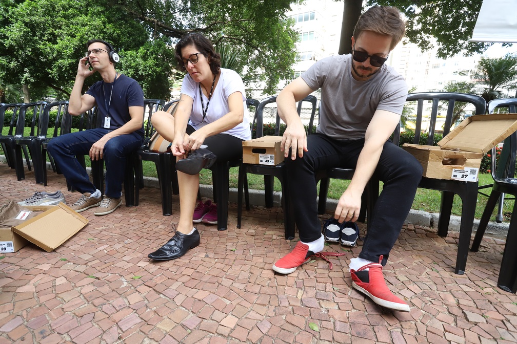 Participantes calçam os sapatos do Museu da Empatia no arruamento do Paço 