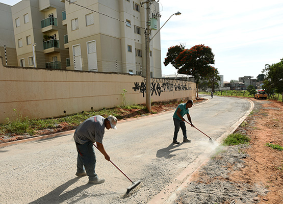 Funcionários trabalham na pavimentação da via com material experimental