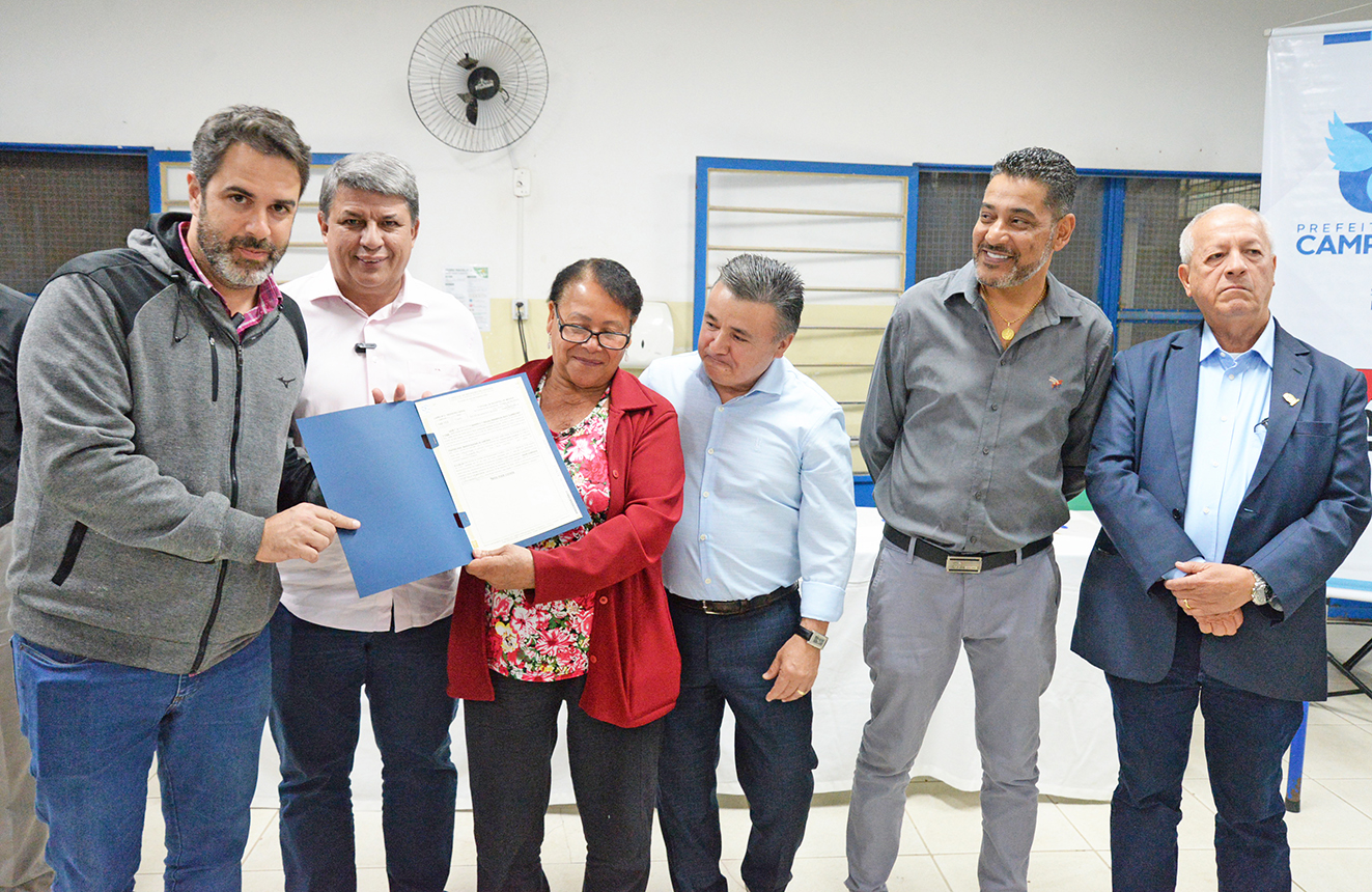 Moradora recebe escritura de imóvel