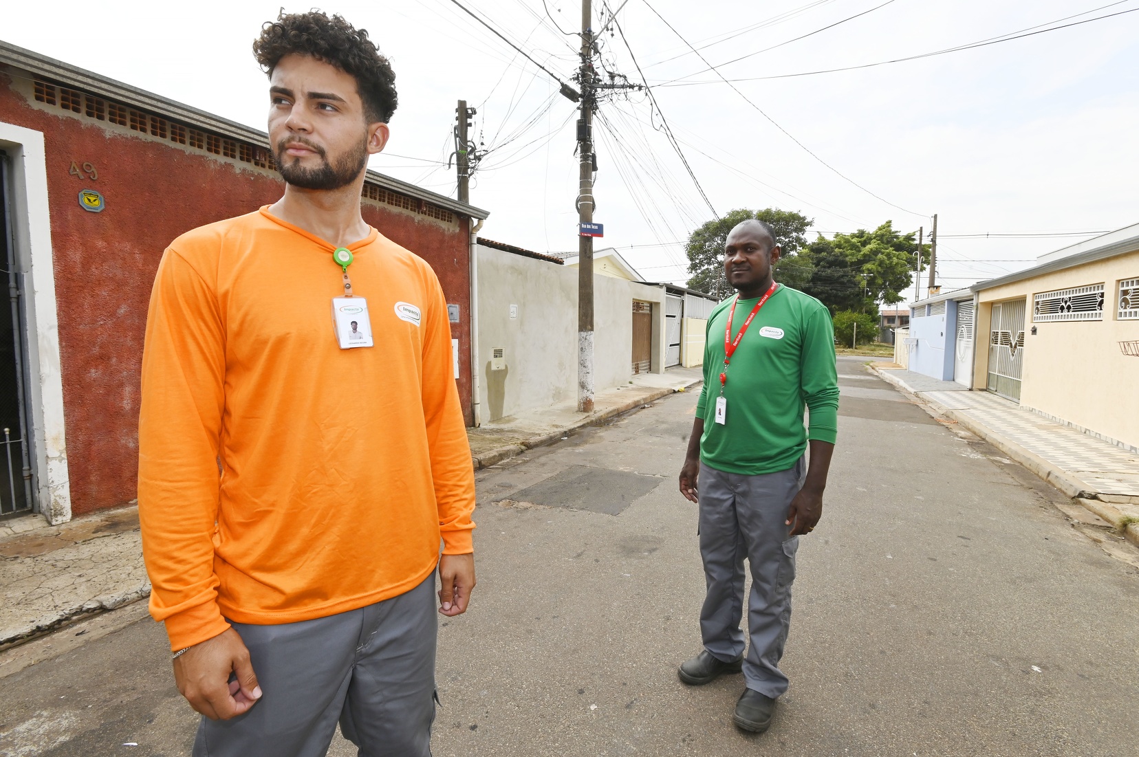 Funcionários de empresa que atua no combate à dengue usam camisetas laranja e verde