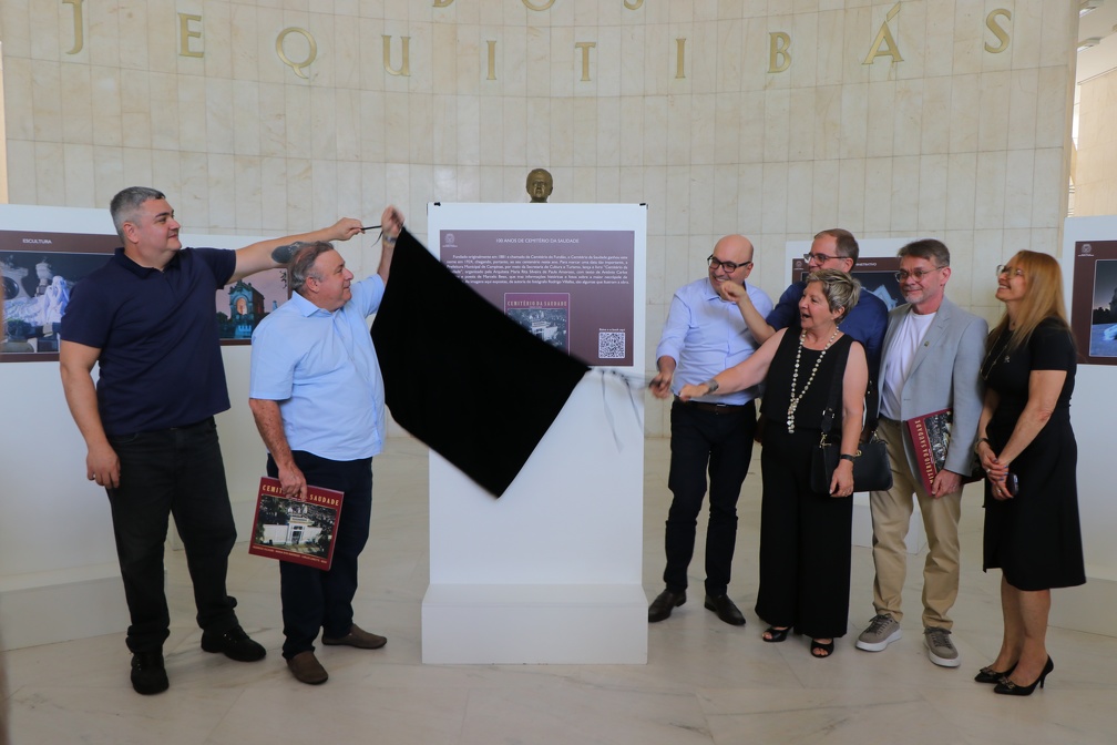 Prefeito e autoridades ao lado dos autores do projeto de livro e exposição na cerimônia