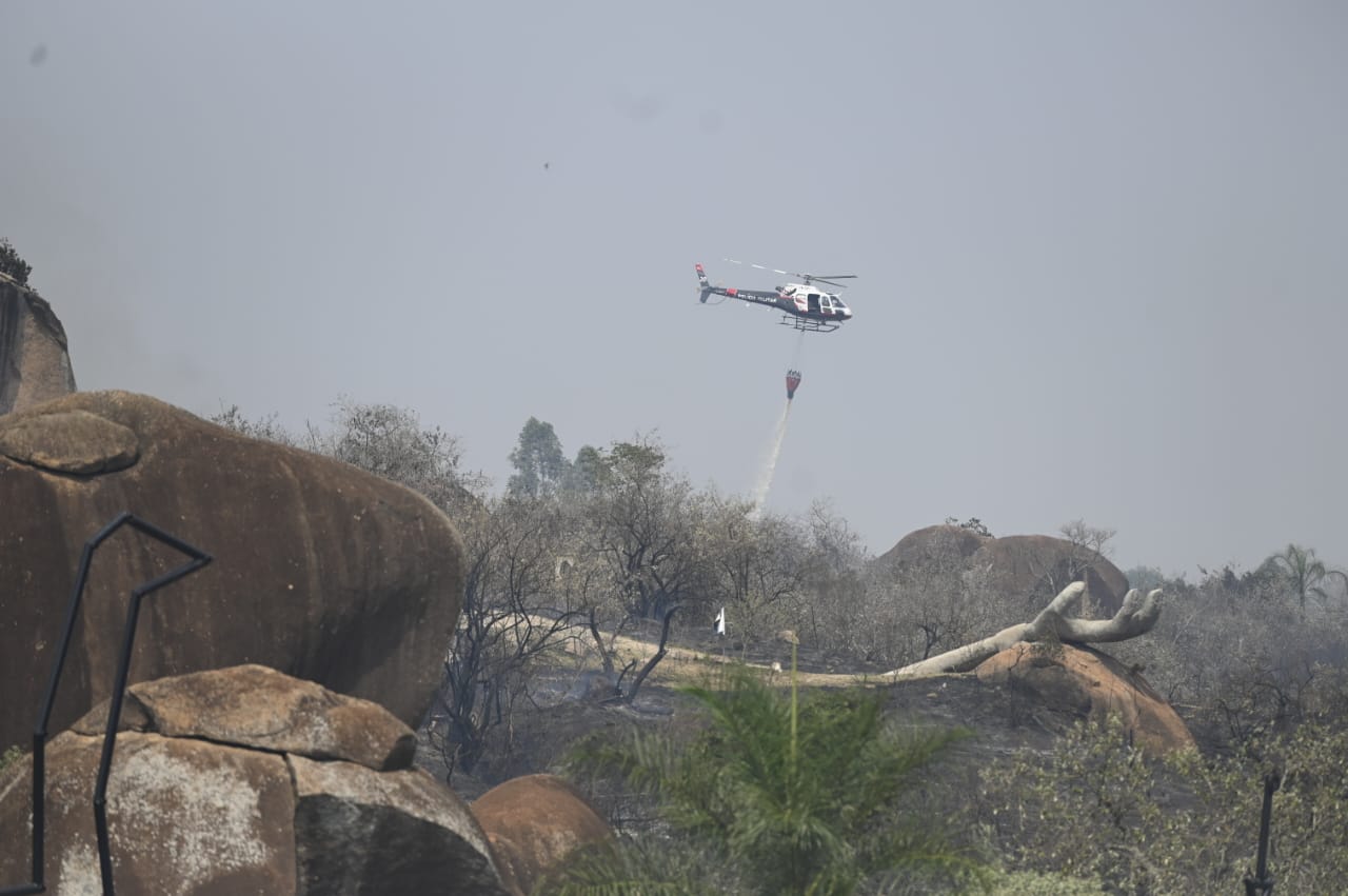 Helicóptero Águia ajuda jogando água em locais de difícil acesso 