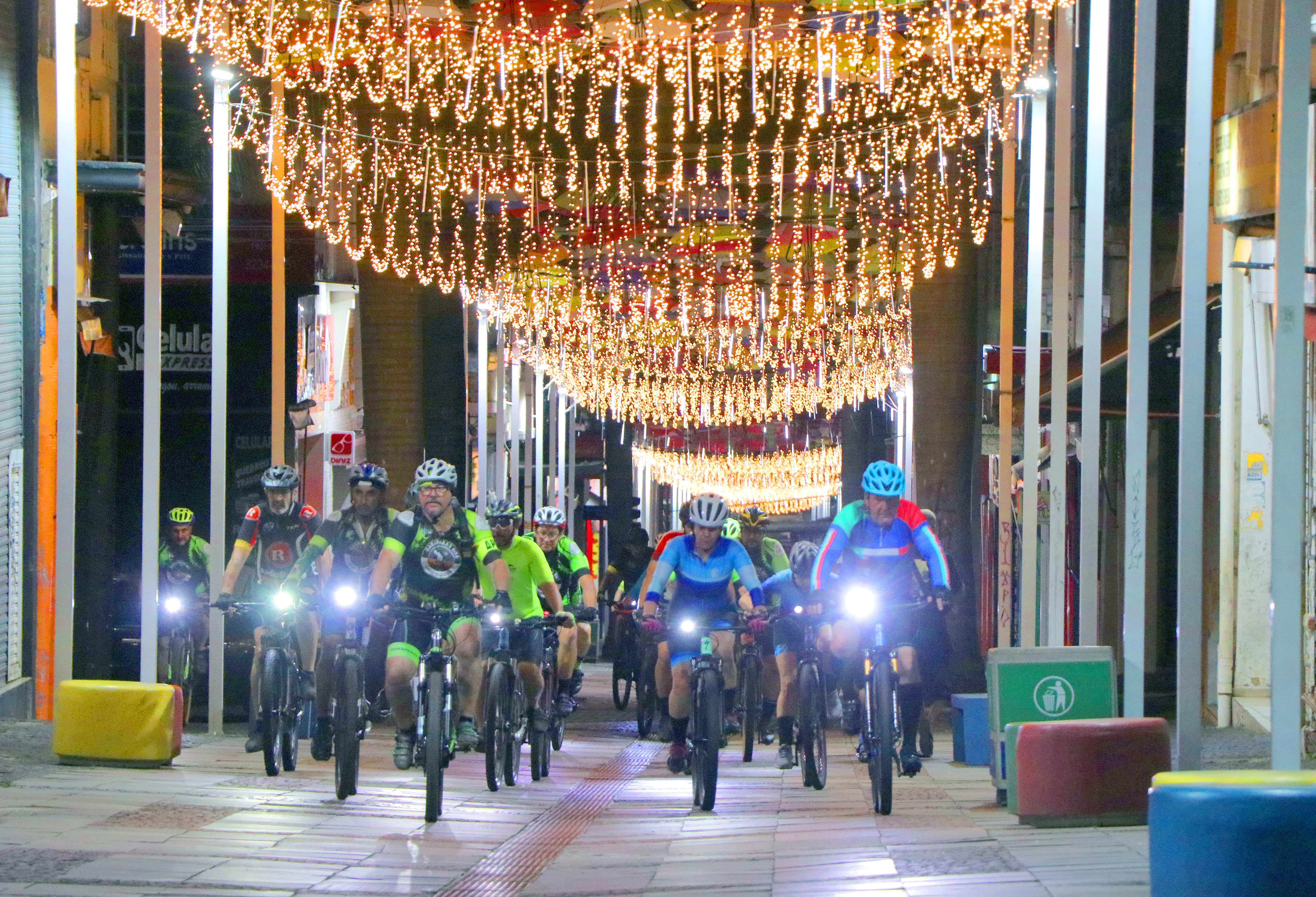 Ciclistas pedalando, à noite, na rua 13 de maio