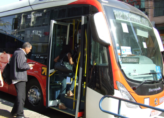 Foto de um cidadão entrando em um ônibus do BRT