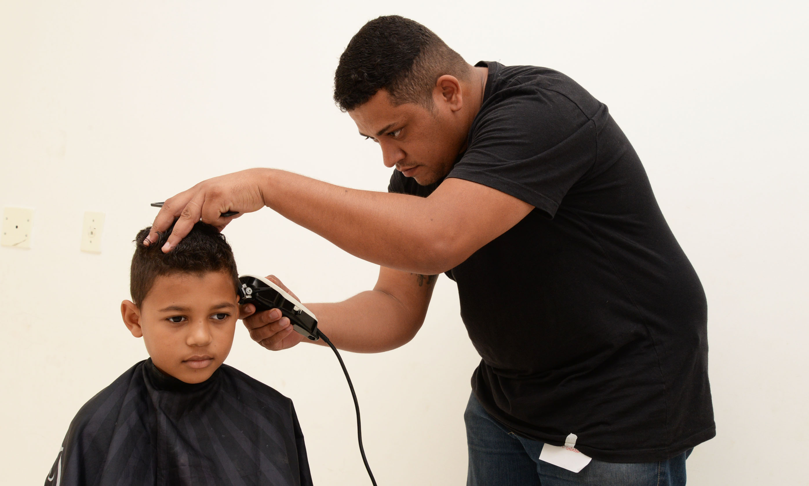 Profissional faz corte de cabelo em garoto