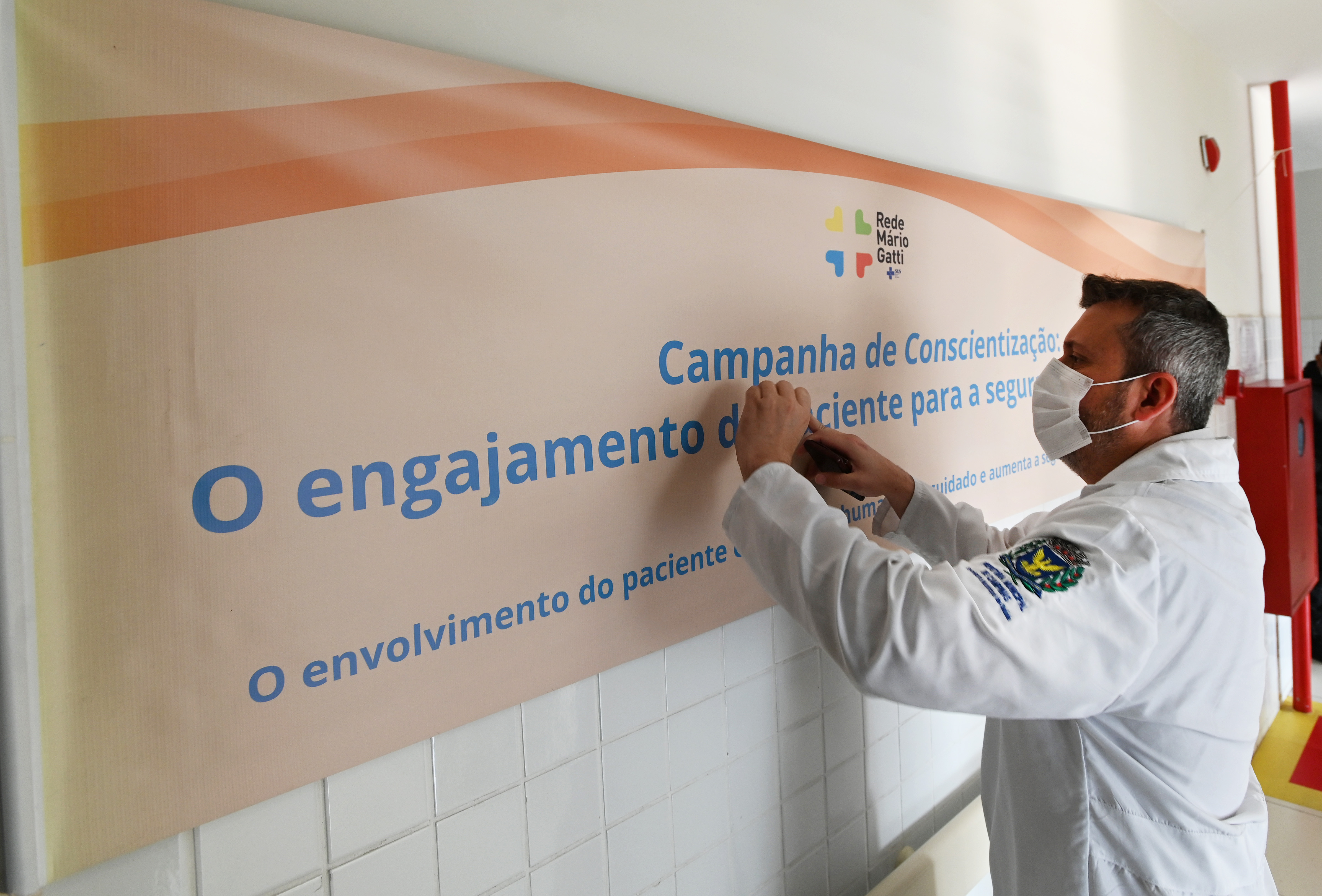 Profissional realiza afixação de cartaz em UPA