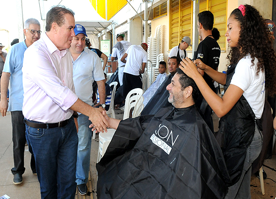 Jonas cumprimenta morador que passa por sessão de corte de cabelo