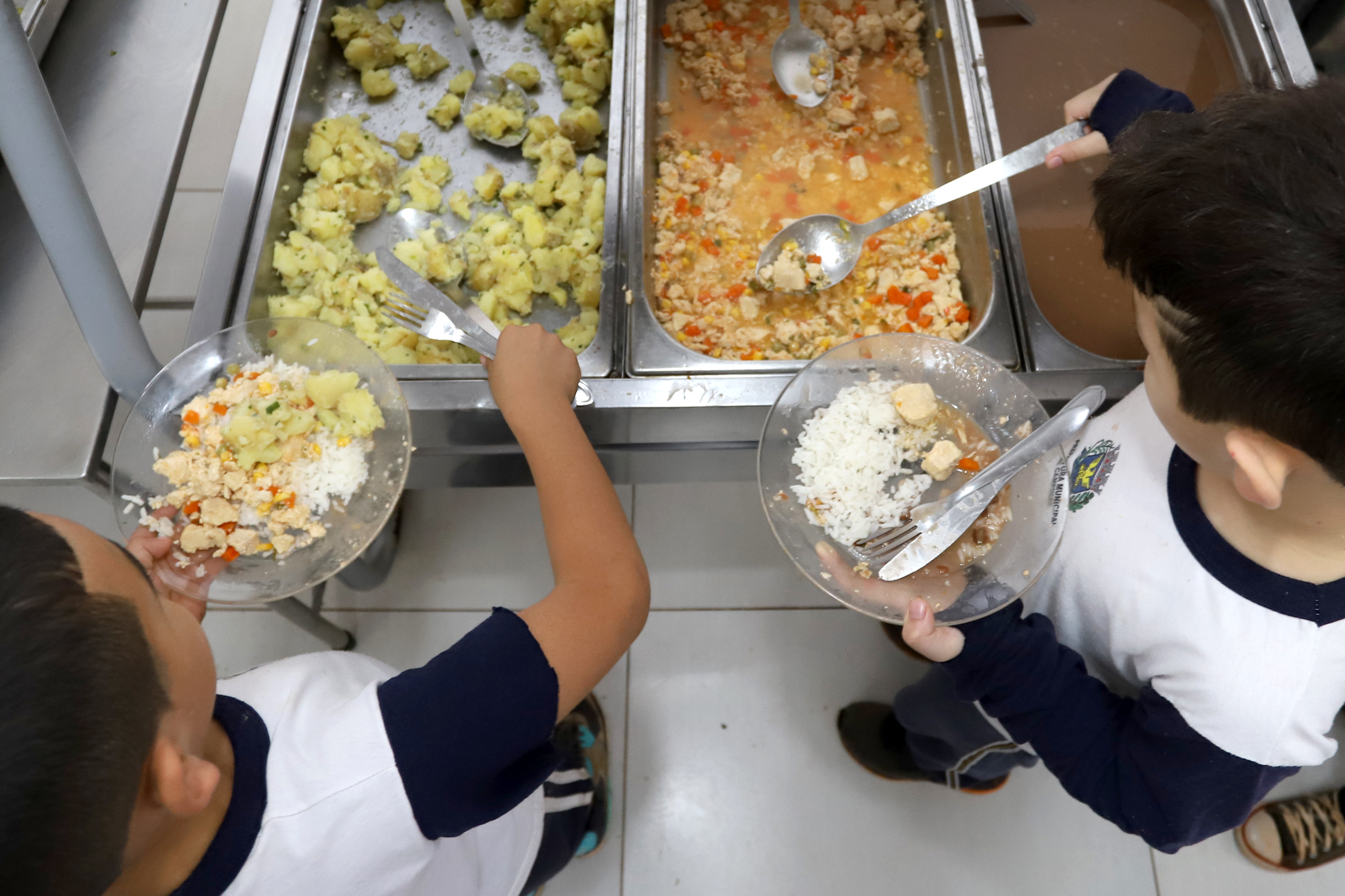 Crianças se servem em refeitório de escola municipal de Campinas 