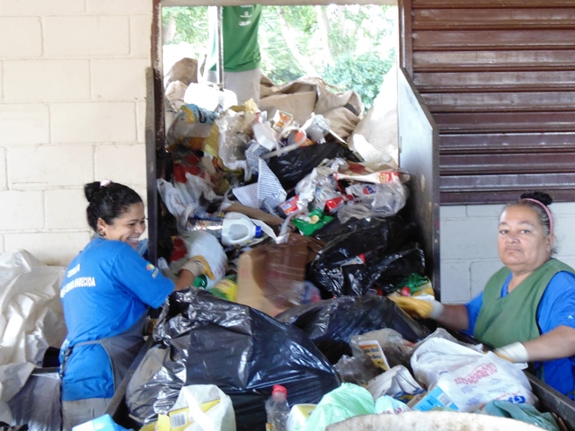 Mulheres trabalham em cooperativa de reciclagem de resíduos