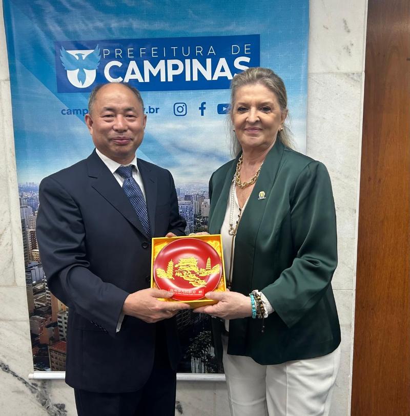 Huang Xuehua, pesquisador do Gabinete de Relações Exteriores do Governo Popular Municipal de Fuzhou, entrega lembrança à secretária Adriana Flosi