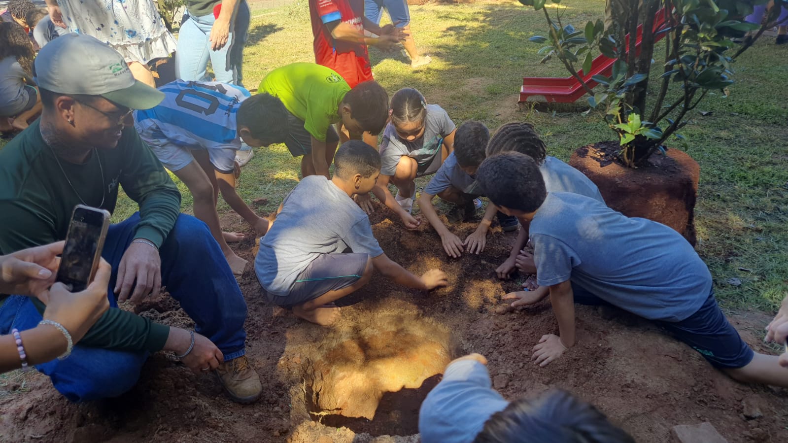 Divulgação Crianças participam do plantio das árvores que, um dia, contribuirão com sombra e clima fresco para as brincadeiras no parquinho