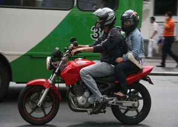 Motociclista com garupa em via de Campinas