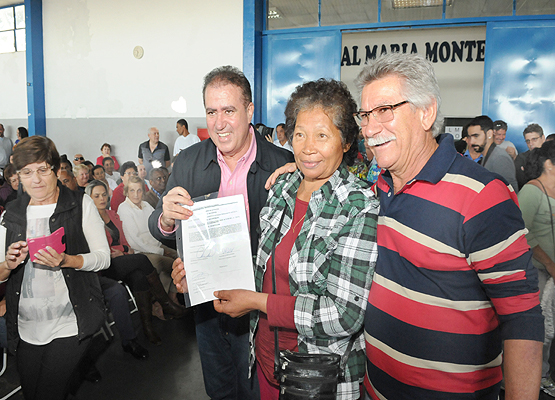 Moradora recebe documento de prefeito