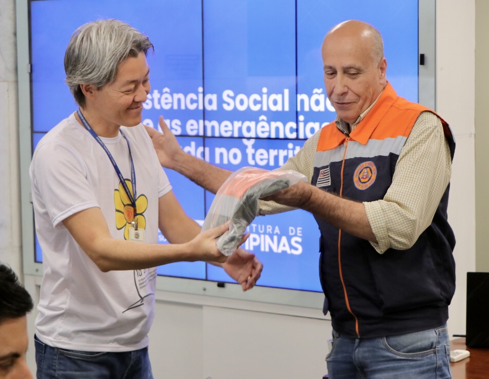 Firmino Piton Diretor da Defesa Civil entrega uniforme da Chuvas de Verão para servidor